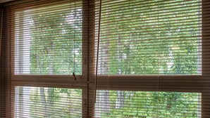 A room with large windows covered by blinds, offering a view of greenery outside. - Kivakatti by Interhome (Sotkamo)