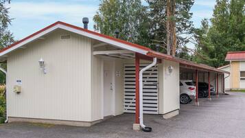 A single-story building with a red roof and a covered parking area.