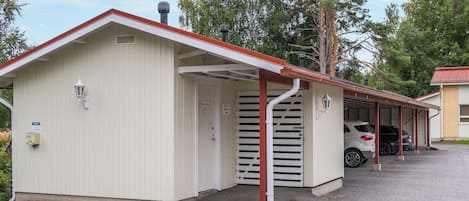 Un bâtiment d’un seul étage, doté d’un toit rouge et d’un espace de stationnement couvert.