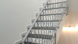 A staircase with patterned steps and a metal railing. - Donna Beatrice AmMare beach house (Donnalucata)