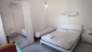 A bedroom with a bed, a nightstand, a mirror, and a wall decoration. - Donna Beatrice AmMare beach house (Donnalucata)