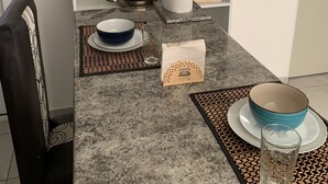 Eine Küche mit Mikrowelle, Herd, Spüle und einer Arbeitsfläche mit verschiedenen Küchenutensilien.