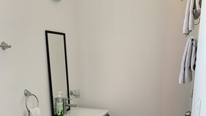 Ein kleines, sauberes Badezimmer mit Toilette, Waschbecken und Spiegel.