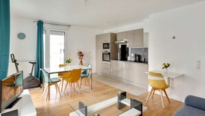 A modern apartment with a dining area, kitchen, and living space. - Chic apart with parking near Paris (Nanterre)