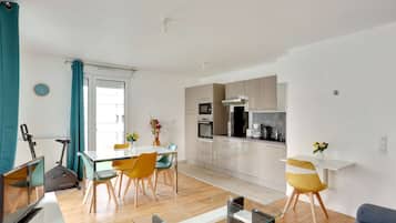 Un appartement moderne comprenant un coin repas, une cuisine et un espace de vie.
