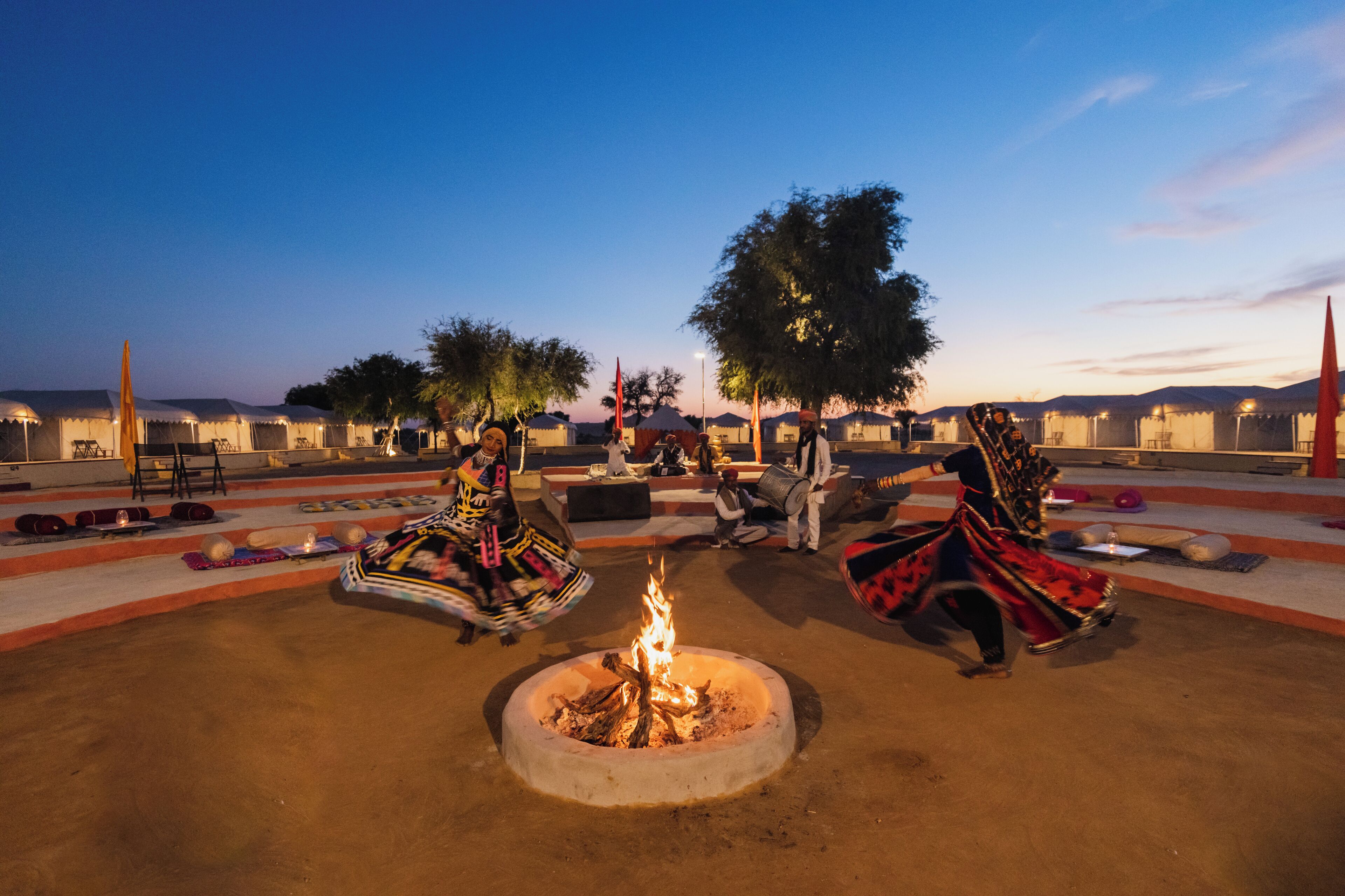 An outdoor seating area with a fire pit, tables, and chairs.