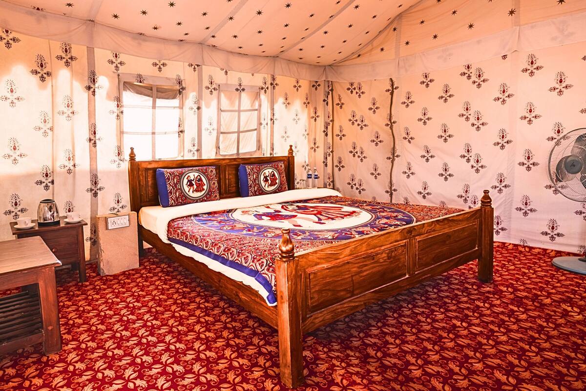 A traditional room with a wooden bed, patterned curtains, and a fan.