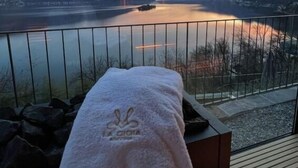 A balcony with a towel, overlooking a calm lake and mountains during sunset. - Garden Suite by Interhome (Ronco sopra Ascona)