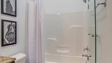Een bad/douchecombinatie, een haardroger, handdoeken, shampoo