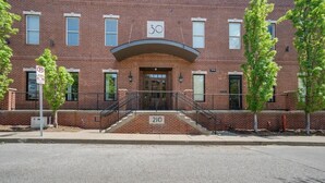A brick building with a number '30' sign above the entrance, a '210' sign at the bottom, and a 'No Parking' sign on the left. - Lofts at 30th-Urban Nest-4 Mins to Broadway! (Nashville)