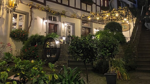 A traditional half-timbered building with a stone well, potted plants, and a wooden staircase. - Beautiful apartment with a view of the vineyards/on the banks of the Moselle/2 terraces just for you (Bruttig-Fankel)
