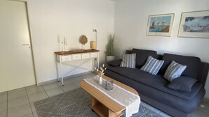 A living room with a dark sofa, a wooden coffee table, and a patterned rug. - Beautiful apartment with a view of the vineyards/on the banks of the Moselle/2 terraces just for you (Bruttig-Fankel)