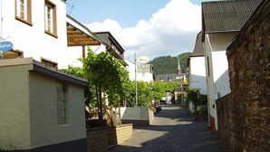A narrow cobblestone street lined with buildings, including a visible restaurant sign. - Beautiful apartment with a view of the vineyards/on the banks of the Moselle/2 terraces just for you (Bruttig-Fankel)