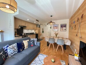 A modern apartment with a living room, dining area, and kitchen.