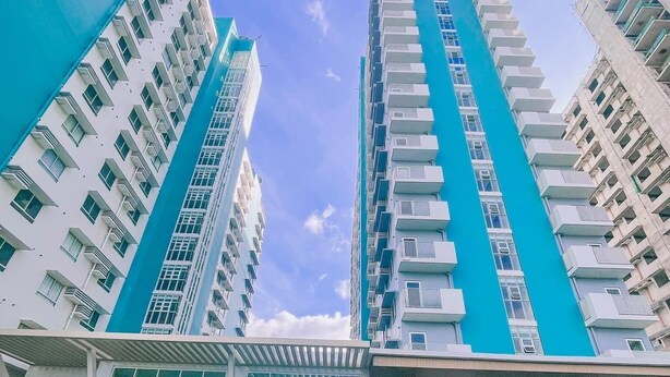 A modern high-rise building with a swimming pool in the foreground.