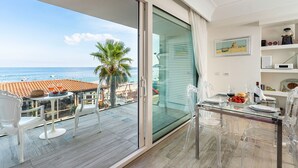 A balcony with a glass table and chairs, a dining area with a glass table, and a view of the sea. - Exceptional modern apartment with majestic sea view in Letojanni - DiCasaInSicilia (Letojanni)