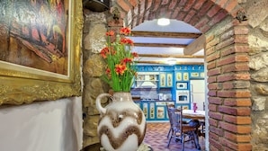 A rustic interior with a decorative vase on a table, a brick wall, and a blue and white patterned wall. - Luxury Chalet with private swimmingpool located in residential Saxon area (Cristian)