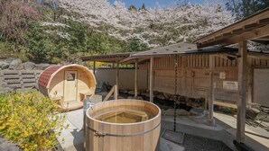 Een traditioneel Japans onsen met houten constructies en een stenen bad.