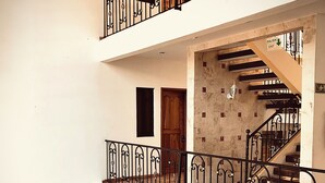 A multi-level interior with a staircase, metal railings, and a door marked "SALIDA EXIT". - Quinta Sea (Playa del Carmen)