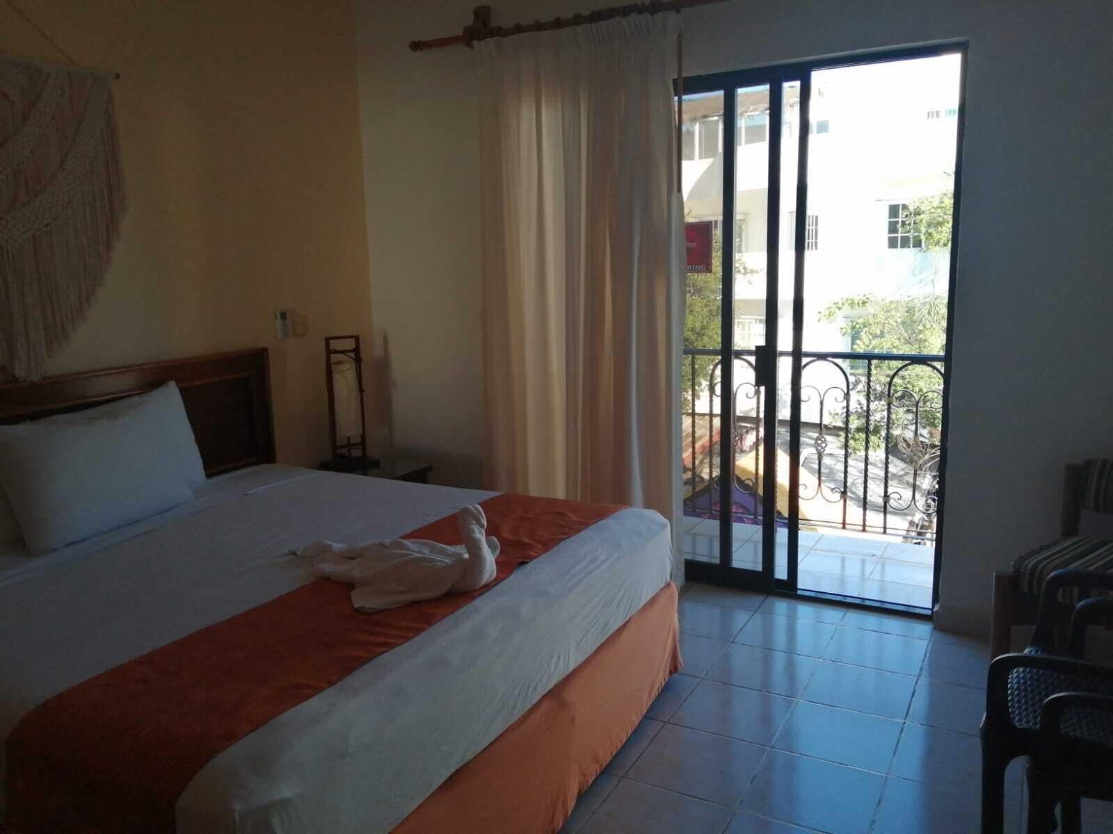 Ein Hotelzimmer mit Bett, Balkon und Blick.
