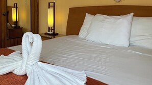 A hotel room with a bed, a large mirror, a macrame wall hanging, and a towel on the floor. - Quinta Sea (Playa del Carmen)