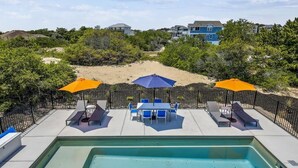 A pool area with a hot tub, lounge chairs, and umbrellas. - Your Fresh Beach Oasis! (Corolla)