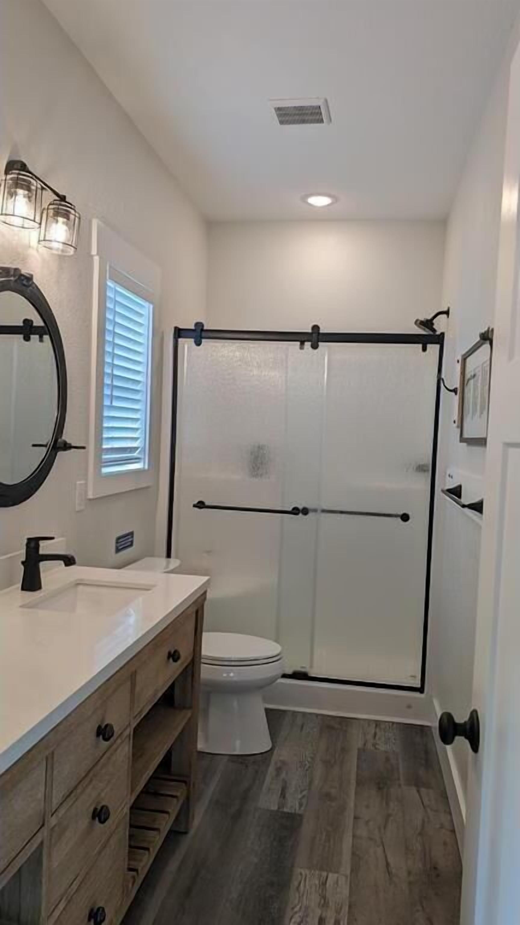 Your private bathroom features modern farmhouse style with a spacious walk-in shower, elegant fixtures, and plenty of natural light for a refreshing start to your day.