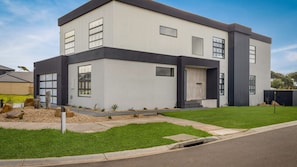 A modern two-story house with a garage, large windows, and a well-maintained lawn. - The Manor with spa in Cowes (Cowes)