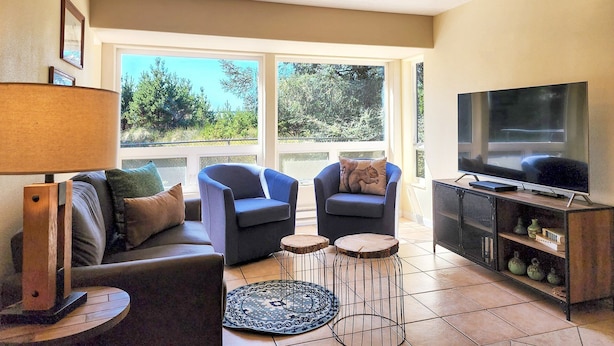 A living room with a sofa, two armchairs, a coffee table, a TV, and a bookshelf. - Fisherman's Delight in Waldport! Dog Friendly! Hot tub! (Waldport)