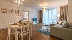 A modern living room with a dining area, a sofa, and a television. - Easyrooms Dzirnavu (Riga)