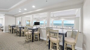 A spacious dining area with a view of the ocean, featuring a long table and multiple chairs. - 1105 Dimucci Twin Towers (Daytona Beach Shores)