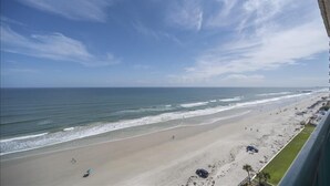 A beach view from a balcony with a clear sky and ocean. - 1105 Dimucci Twin Towers (Daytona Beach Shores)