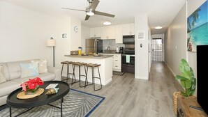 A modern kitchen with white cabinets, stainless steel appliances, and a central island.