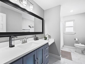 Bathtub, hair dryer, towels, shampoo