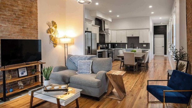 A modern living room with a flat-screen TV, grey sofa, and a coffee table. - Two Condos for 14 Guests, 5 Bedrooms, Free Parking (Covington)