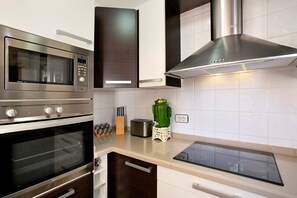 A kitchen with a built-in microwave, oven, and a modern induction cooktop.