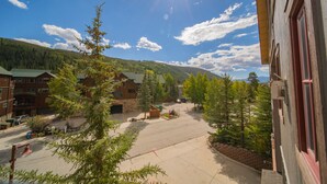 A hotel courtyard with a paved area, surrounded by trees and buildings. - Oversized | Walk to Summer Fun | Pool & Hot tub (Keystone)