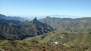 A mountainous landscape with a prominent peak, a valley with scattered buildings, and a clear sky. - Vacation Home 'Chalet Rural Marian' with Sea View, Garden & Wi-Fi (Santa María de Guía)