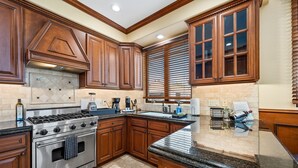 A kitchen with wooden cabinets, a stainless steel stove, and a granite countertop.