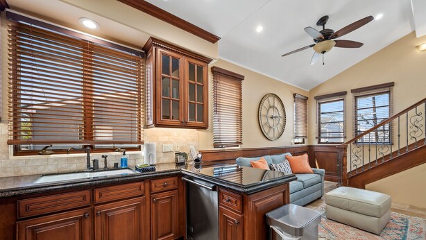 A kitchen with wooden cabinets, a built-in oven, and a large island with a sink.