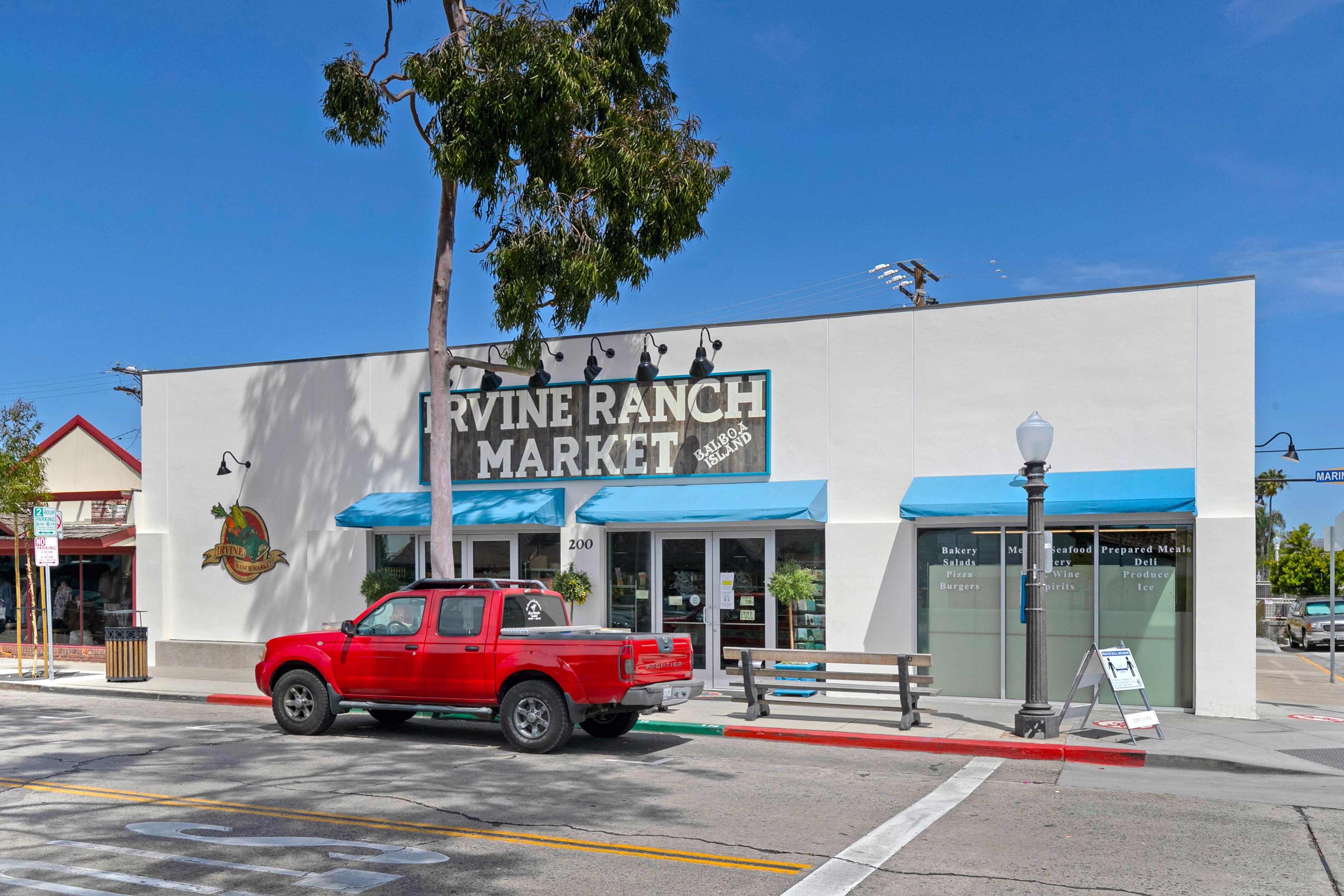 Una camioneta roja estacionada frente al edificio de Irvine Ranch Market.