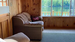 Una cabaña de paredes de madera con vista a un lago.
