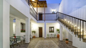 A spacious courtyard with a tiled floor, a staircase, and a balcony with a railing. - CASA VERDE Comfortable Air-Conditioned (Ingenio)