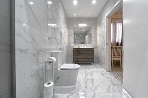 A modern bathroom with a toilet, bidet, and vanity. - CASA VERDE Comfortable Air-Conditioned (Ingenio)