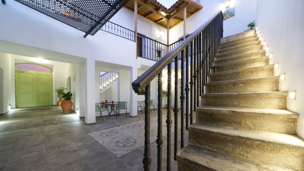 A spacious interior with a stone staircase, a green door, and a balcony with railings. - CASA VERDE Comfortable Air-Conditioned (Ingenio)