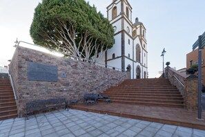 A staircase leading to a church with a bell tower, a plaque on the wall, and a bench. - CASA VERDE Comfortable Air-Conditioned (Ingenio)