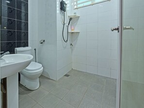 A bathroom with a toilet, sink, and shower.