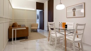 A modern living area with a sofa, chairs, a glass-top dining table, and a pendant light. - w* | Upscale 1BR with Amazing Deco in Polanco (Ciudad de México)