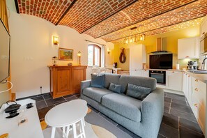 A compact living space with a sofa, dining table, and kitchen area.