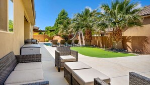 A patio area with outdoor furniture, a pool, and palm trees. - DUNE-OUR-THING, PRIVATE POOL, BBQ, BASKETBALL, PUTTING GREEN, SAND HOLLOW (Hurricane)